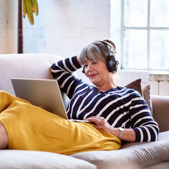 Frau mit Computer auf Sofa